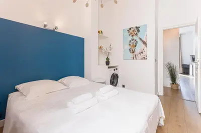 a bedroom with a white bed with a blue wall at 