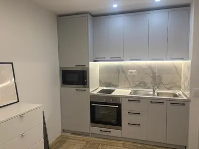 a kitchen with white cabinets and a sink at studio Pointe Croisette avec terrasse in Cannes
