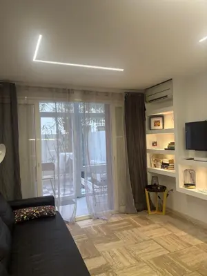a living room with a couch and a sliding glass door at studio Pointe Croisette avec terrasse in Cannes
