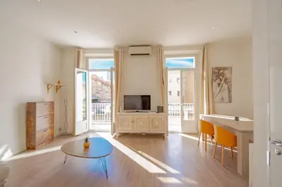 a living room with a television and a table at Bel appartement avec balcon centre ville in Cannes
