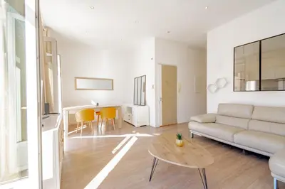 a living room with a couch and a table at Bel appartement avec balcon centre ville in Cannes