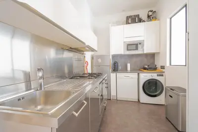a kitchen with a sink and a washing machine at Bel appartement avec balcon centre ville in Cannes