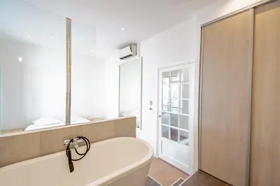 a white bath tub in a bathroom with a window at Bel appartement avec balcon centre ville in Cannes