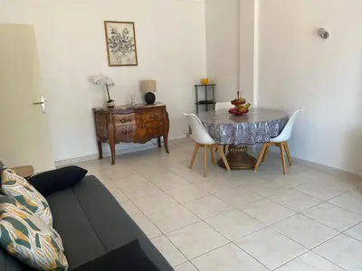 a living room with a table and chairs at Charming apartment in the centre of Cannes in Cannes