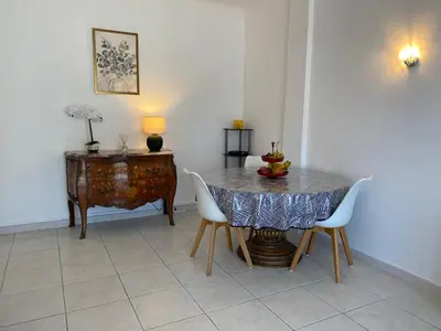 a dining room with a table and chairs and a desk at Charming apartment in the centre of Cannes in Cannes
