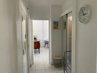 a hallway with a clock on a wall at Charming apartment in the centre of Cannes in Cannes