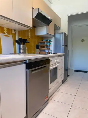 a kitchen with stainless steel appliances and yellow tiles at Charming apartment in the centre of Cannes in Cannes