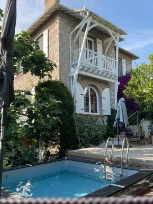 a building with a swimming pool in front of a house at Villa 12MN Walk from le palais in Cannes