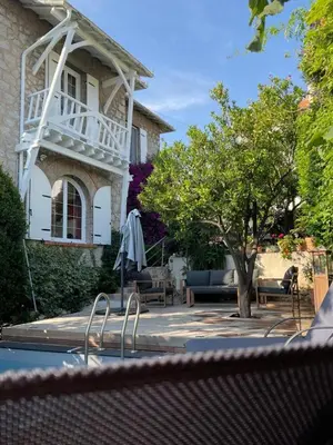 a house with a table and chairs and a tree at Villa 12MN Walk from le palais in Cannes