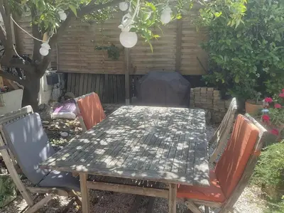 a table and chairs in a backyard with a garden at Villa 12MN Walk from le palais in Cannes