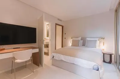 a bedroom with a bed and a desk with a television at La Réale Croisette in Cannes