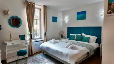 a bedroom with a large bed with a blue headboard at LB Vacation Rentals I Superieure Room 22m2 - Spacious I Casa d'Azur in Cannes
