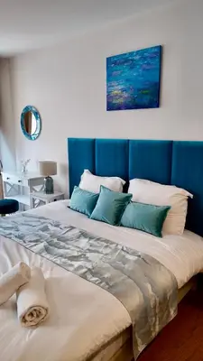 a large bed with a blue headboard in a room at LB Vacation Rentals I Superieure Room 22m2 - Spacious I Casa d'Azur in Cannes