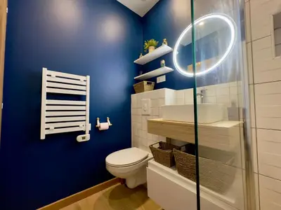 a bathroom with a toilet and a blue wall at Rêve Bleu By SCLS Locations in Cannes