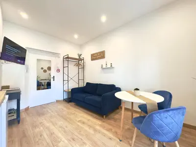 a living room with a blue couch and a table at Rêve Bleu By SCLS Locations in Cannes