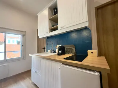 a kitchen with white cabinets and a counter top at Rêve Bleu By SCLS Locations in Cannes