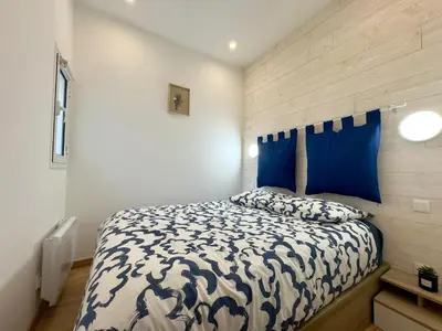 a bedroom with a bed with a blue and white comforter at Rêve Bleu By SCLS Locations in Cannes