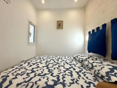a bedroom with a bed with a blue and white comforter at Rêve Bleu By SCLS Locations in Cannes
