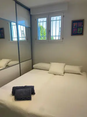 a large white bed in a room with two windows at Cannes in Cannes