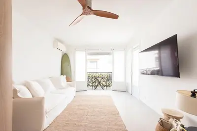 a living room with a white couch and a ceiling fan at Bright 1-Br Apartment Walk to the Beach in Cannes