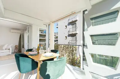 a dining room with a table and chairs and a large window at Bright 1-Br Apartment Walk to the Beach in Cannes