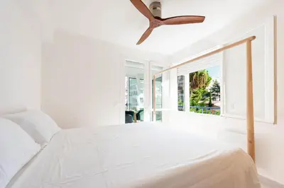 a bedroom with a white bed and a ceiling fan at Bright 1-Br Apartment Walk to the Beach in Cannes