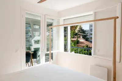a bedroom with a window with a view of a desk at Bright 1-Br Apartment Walk to the Beach in Cannes