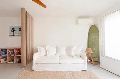 a white couch in a living room with a window at Bright 1-Br Apartment Walk to the Beach in Cannes