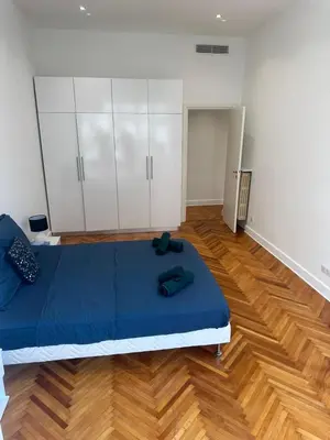 a room with a bed and white cabinets and a wooden floor at Golden House Cannes in Cannes