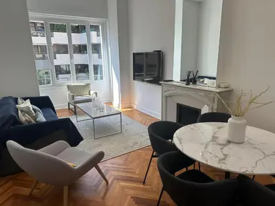 a living room with a couch and a table and chairs at Golden House Cannes in Cannes