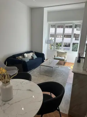 a living room with a blue couch and a table at Golden House Cannes in Cannes