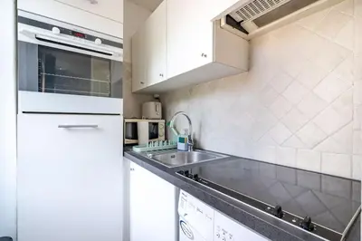 a white kitchen with a sink and a refrigerator at Confortable appartement - Cannes centre le Suquet in Cannes