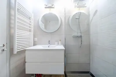 a white bathroom with a sink and a mirror at Confortable appartement - Cannes centre le Suquet in Cannes