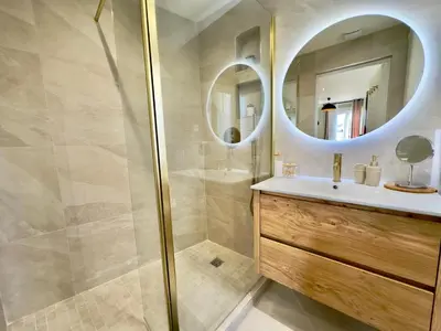 a bathroom with a shower and a sink and a mirror at Cosy Home Cannes - Croisette in Cannes