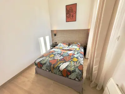 a bedroom with a bed with a colorful comforter at Cosy Home Cannes - Croisette in Cannes