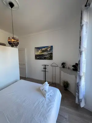 a bedroom with a white bed with a cross on it at FRGK 