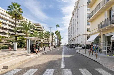 an empty city street with palm trees and buildings at Beautiful apartment, next to Croisette Gray Albion in Cannes