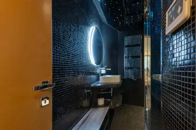 a bathroom with black tiled walls and a sink at RARE! 2-Br with Pools Beach Access Private Parking in Cannes