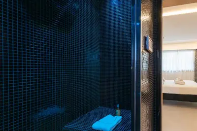 a bathroom with a shower with a blue floor at RARE! 2-Br with Pools Beach Access Private Parking in Cannes