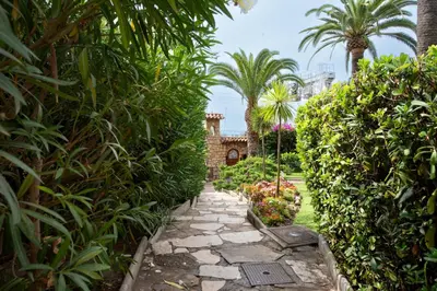 a path through a garden with palm trees and plants at RARE! 2-Br with Pools Beach Access Private Parking in Cannes