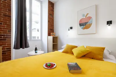 a bedroom with a yellow bed with a plate of fruit on it at L'Elégant YourHostHelper in Cannes