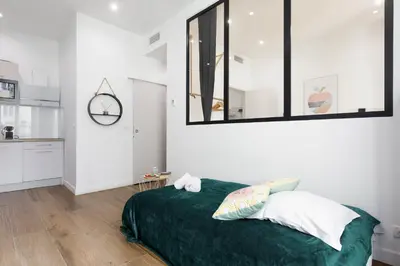 a bedroom with a bed with a green blanket at L'Elégant YourHostHelper in Cannes