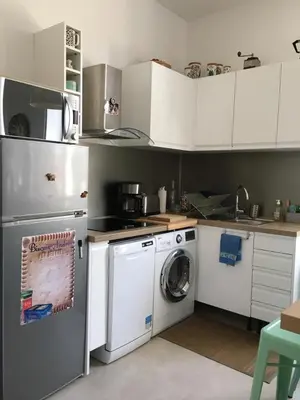 a kitchen with white cabinets and a washing machine at Cannes congrès in Cannes