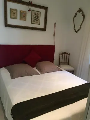 a bedroom with a large bed with a red headboard at Cannes congrès in Cannes