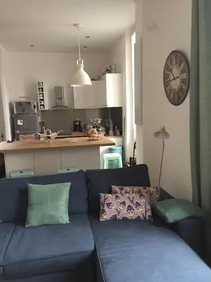 a blue couch in a living room with a clock on the wall at Cannes congrès in Cannes