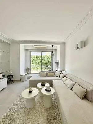 a living room with a large couch and two tables at Apt moderne et luxueux a Cannes Res Miramar in Cannes