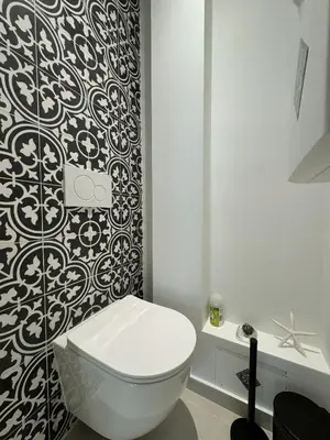 a bathroom with a toilet and a black and white wallpaper at Apt moderne et luxueux a Cannes Res Miramar in Cannes