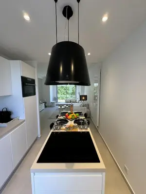 a kitchen with a black light hanging over a stove at Apt moderne et luxueux a Cannes Res Miramar in Cannes