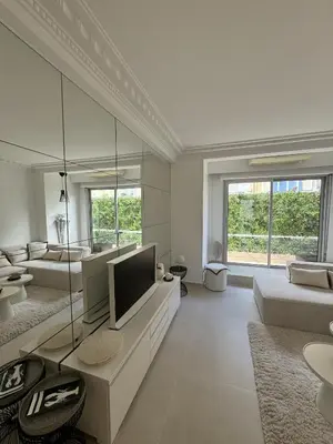 a living room with a television and a couch at Apt moderne et luxueux a Cannes Res Miramar in Cannes