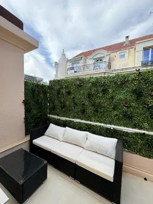 a bench on a balcony with a green hedge at Apt moderne et luxueux a Cannes Res Miramar in Cannes